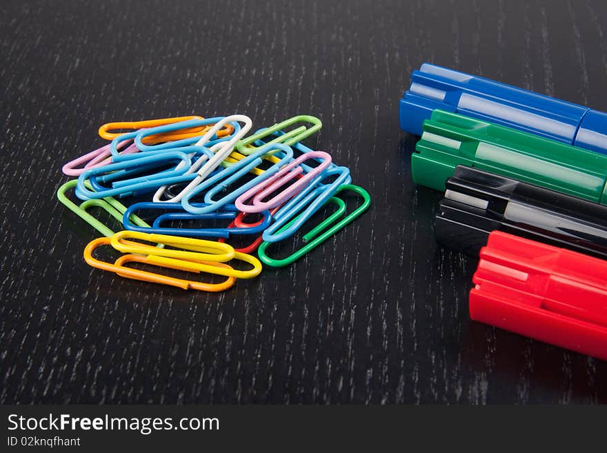 Paper clips and markers on a table