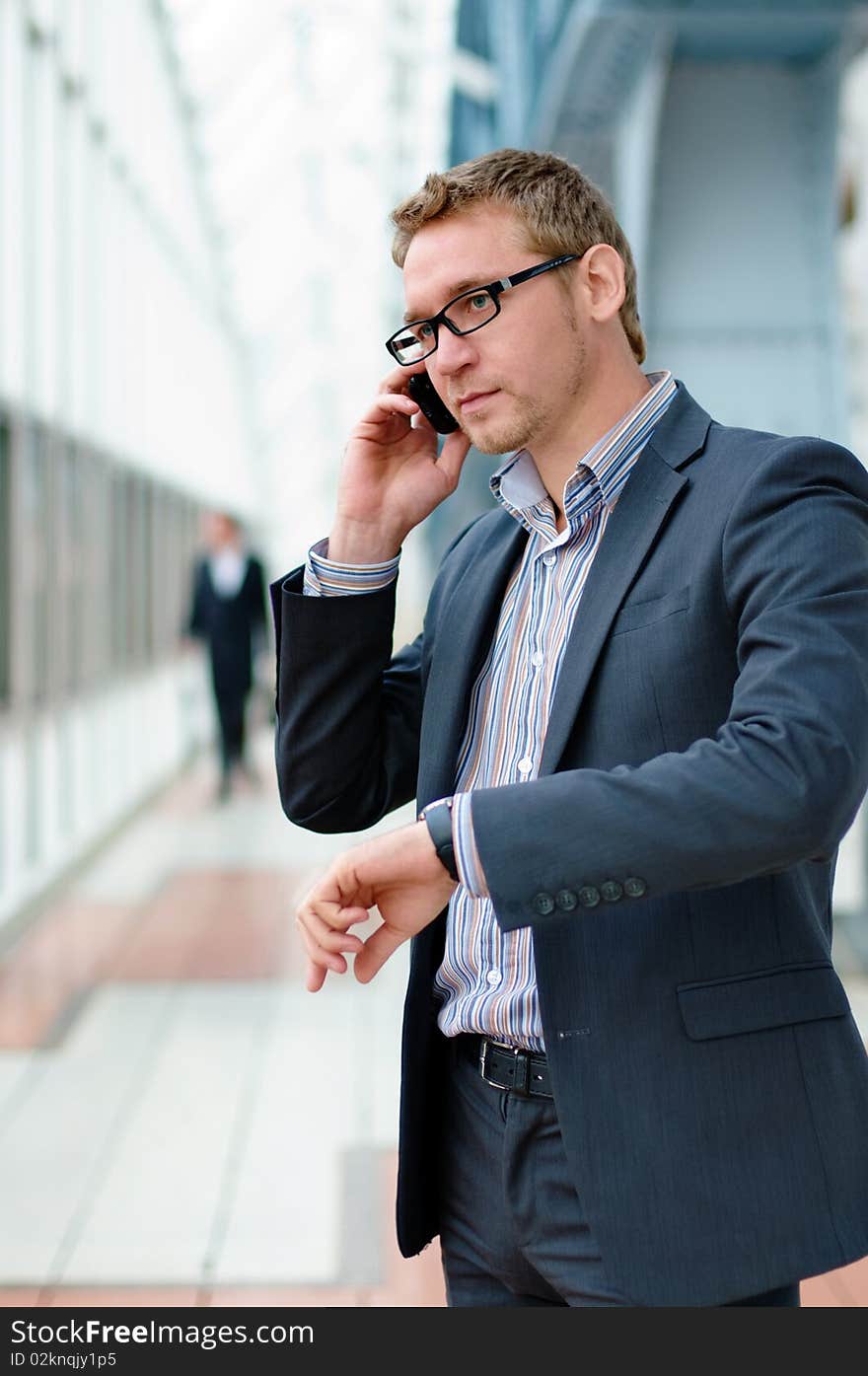 Businessman wearing glasses and a suit using a cell phone. Businessman wearing glasses and a suit using a cell phone