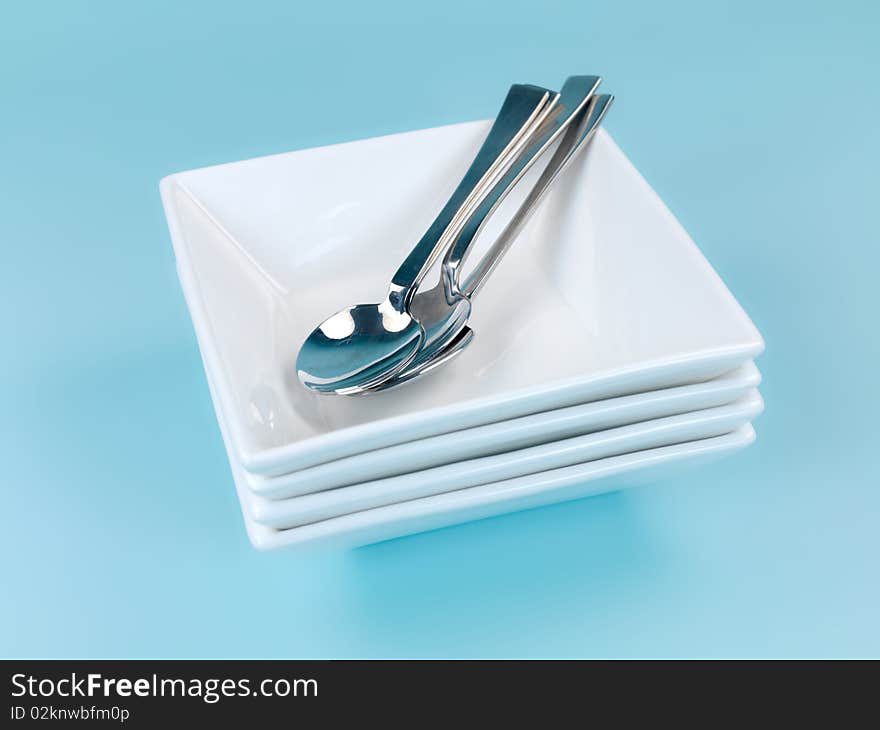 Plates and cutlery isolated against a blue background