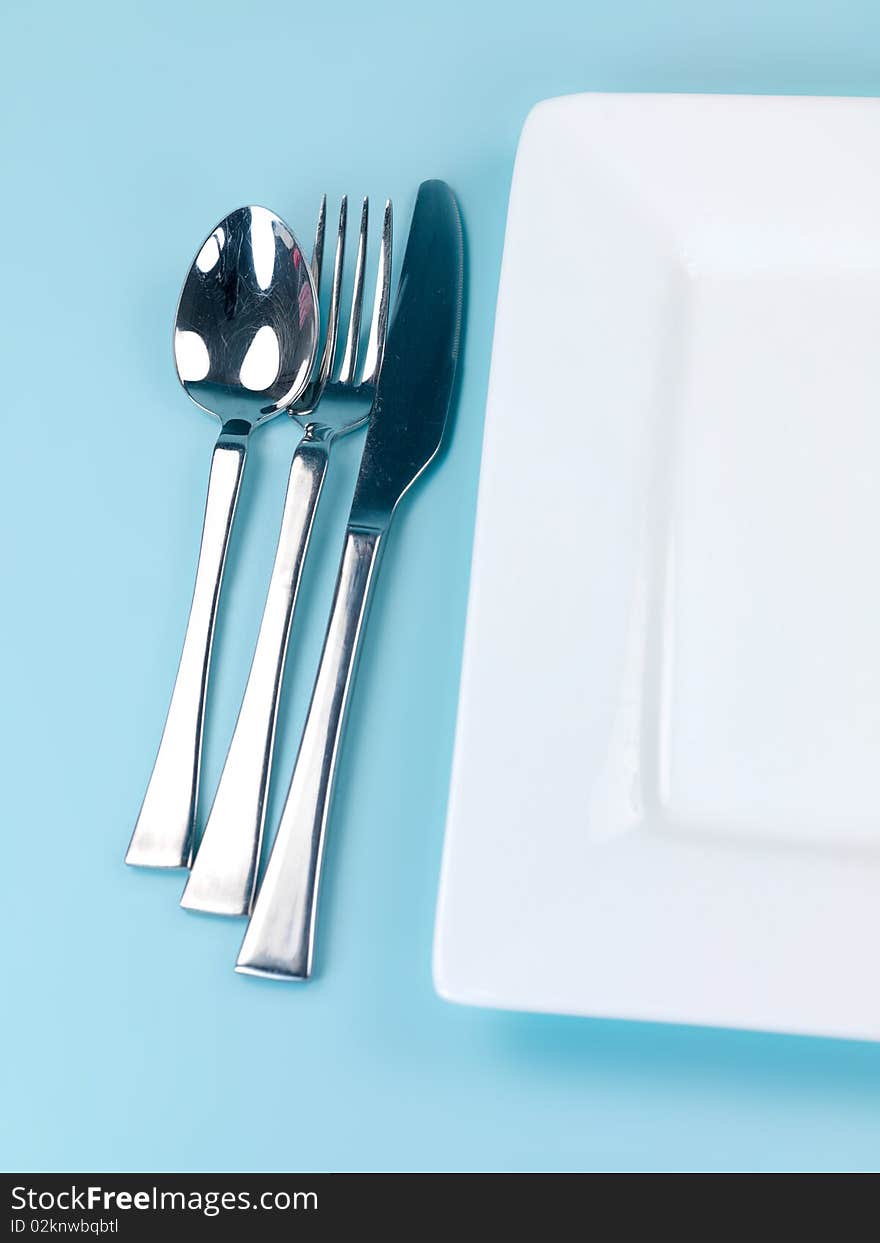 Plates and cutlery isolated against a blue background