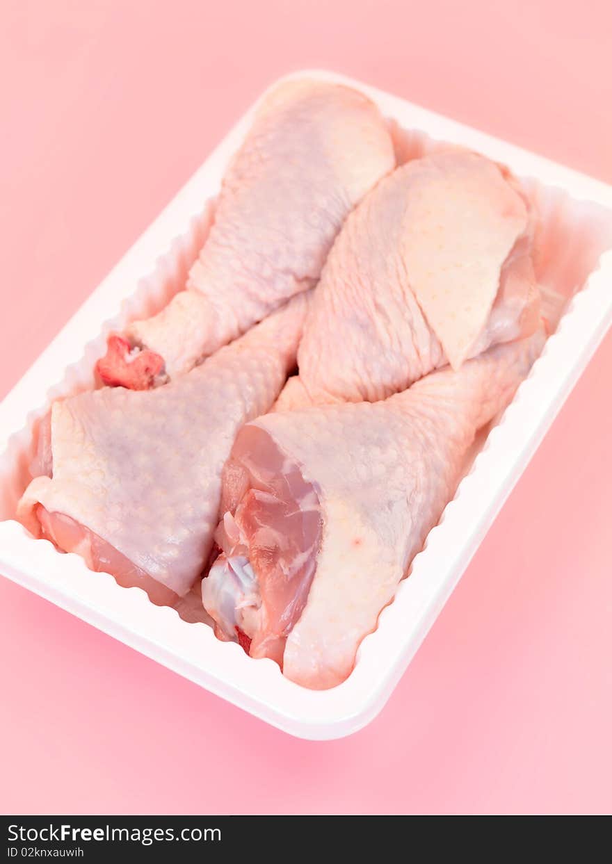 Raw chicken drumsticks on a kitchen bench