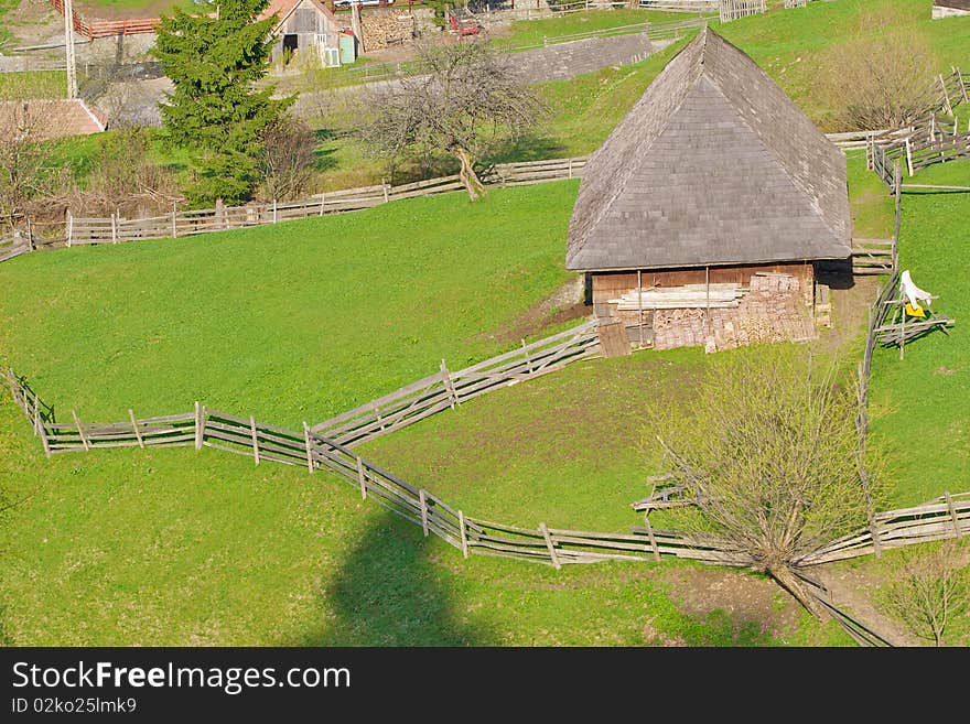 Old mountain wooden cottage in sunset light surrounded by wooden fence. General rural mountain landscape. Old mountain wooden cottage in sunset light surrounded by wooden fence. General rural mountain landscape.