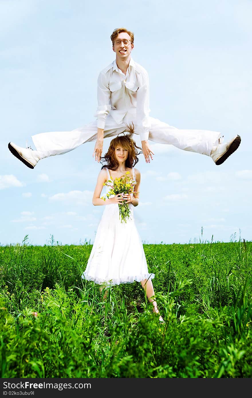 Cute couple jump in a flower field