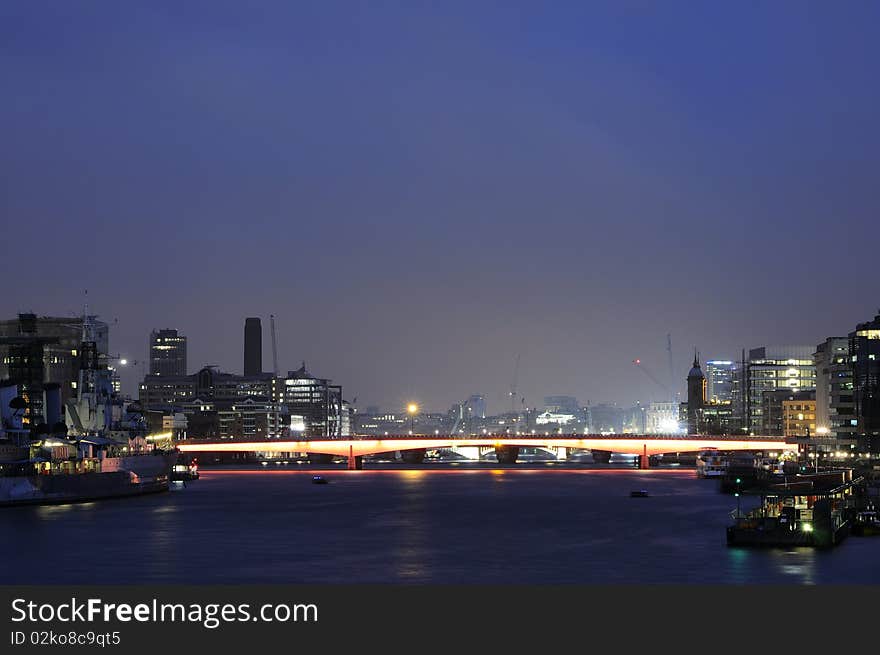 Thames river and London Bridge with illuminated modern buildings in background. Thames river and London Bridge with illuminated modern buildings in background