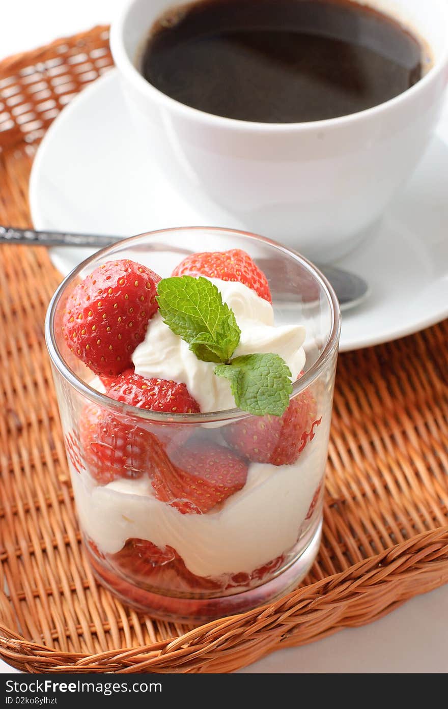 Strawberry dessert and coffee for breakfast in a wicker tray