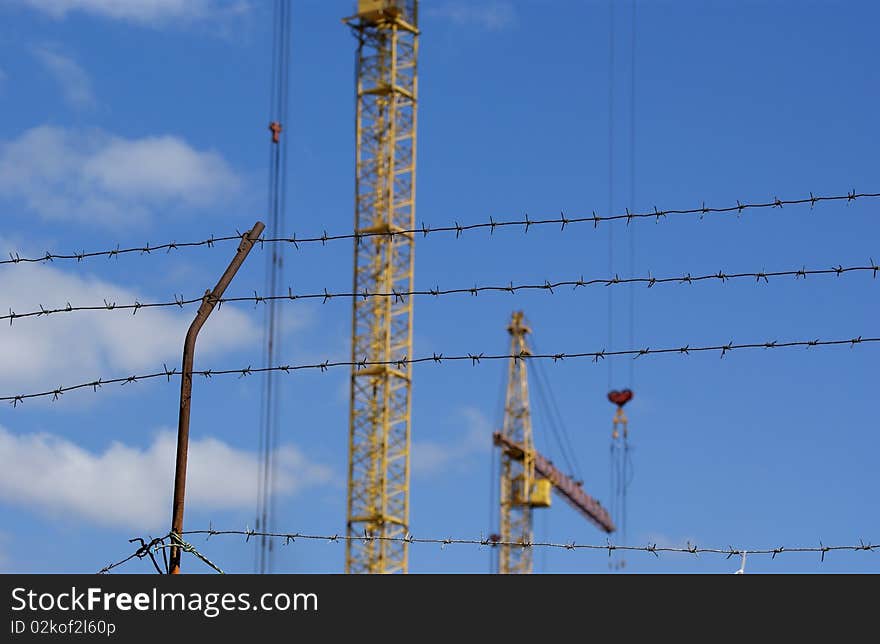 Elevating construction crane against the blue sky in a fair weather