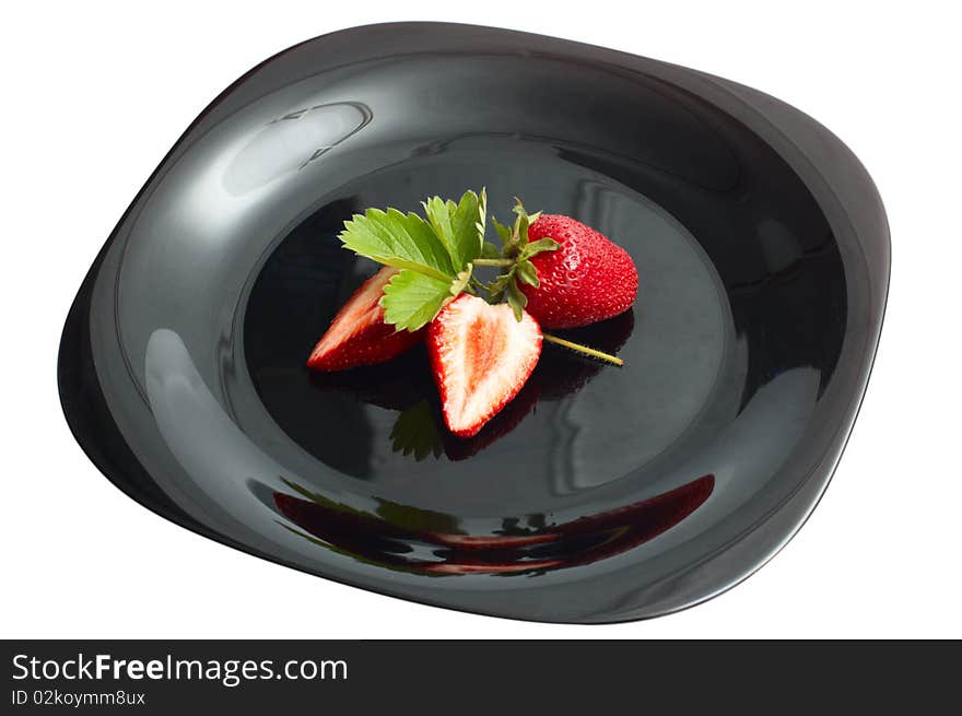 Fresh ripe strawberry on black dish isolated on white