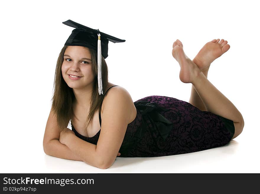 An attractive barefoot teen reclining in her middle-school graduation cap with her graduation dress. Isolated on white. An attractive barefoot teen reclining in her middle-school graduation cap with her graduation dress. Isolated on white.