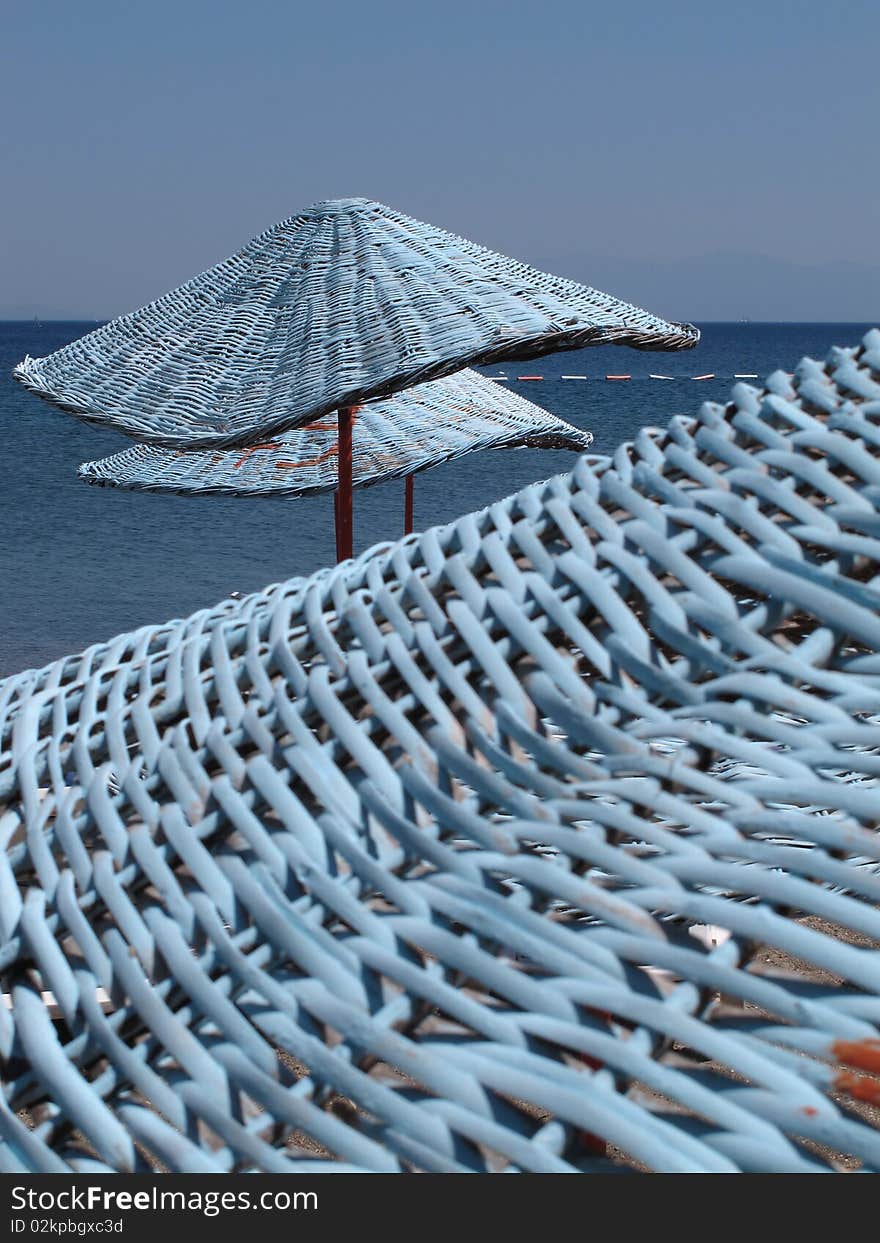 Blue parasols at the beach of Mediterranean sea