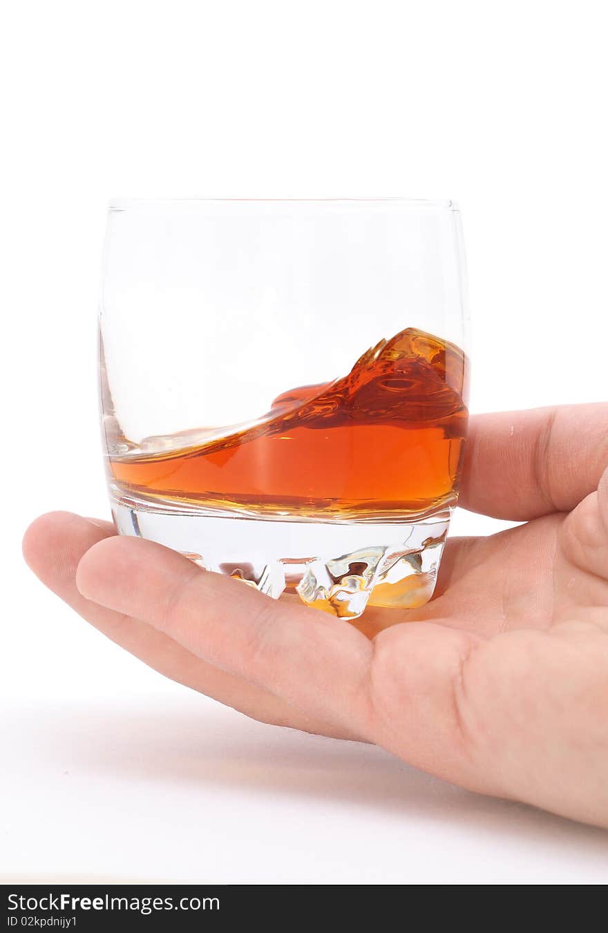 Glass of brandy holding by hand isolated on white