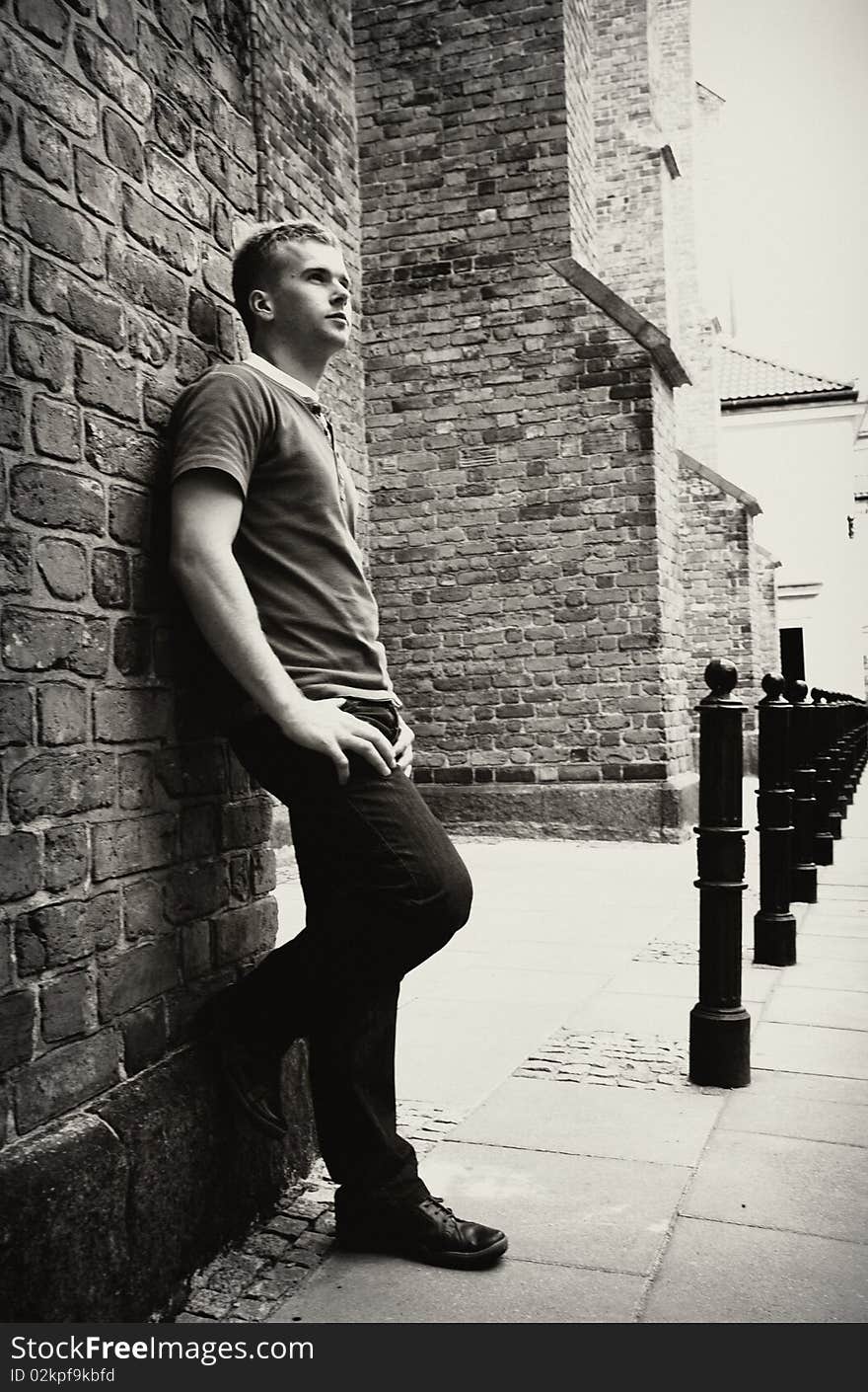 Handsome male standing near wall.