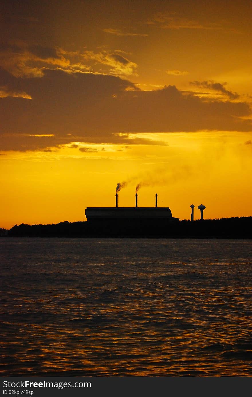 An outline of a factory against sunset. An outline of a factory against sunset