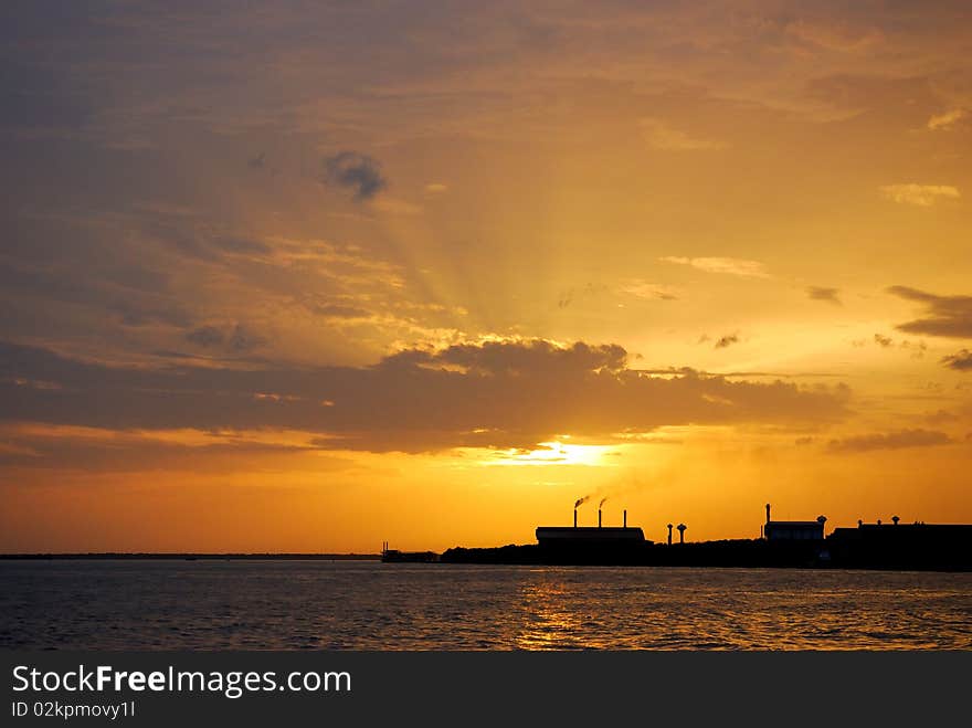 An outline of a factory against sunset. An outline of a factory against sunset