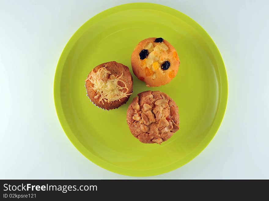 Three kind of cup cake on the green dish. 1.Banana cup cake 2.Raisin cup cake 3.Cashew nut cup cake. Three kind of cup cake on the green dish. 1.Banana cup cake 2.Raisin cup cake 3.Cashew nut cup cake