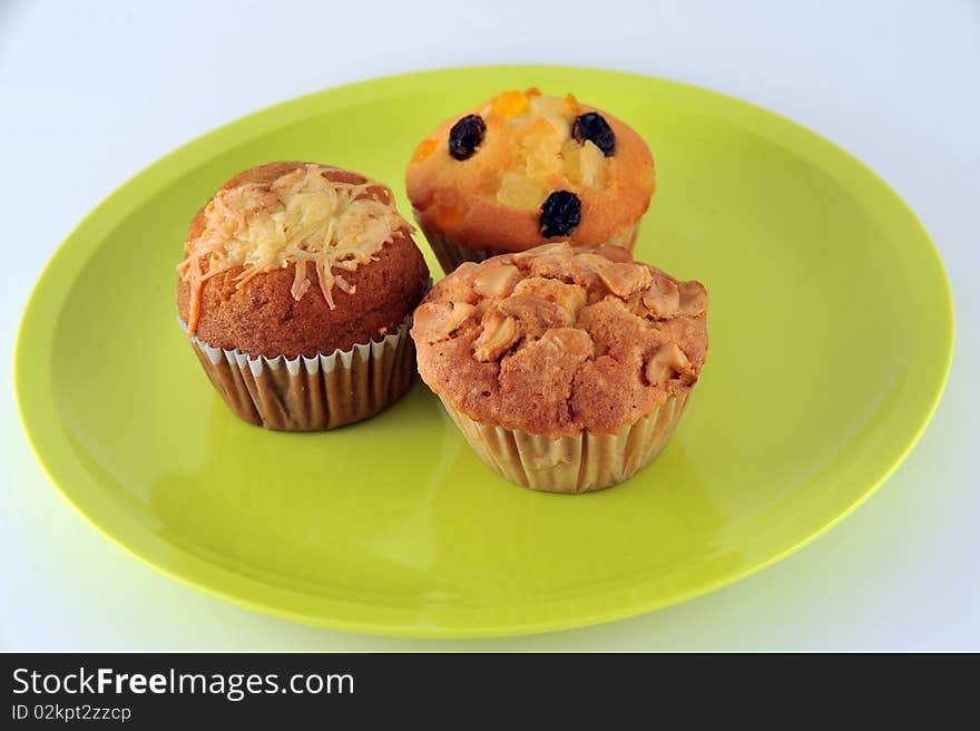 Three kind of cup cake on the green dish. 1.Banana cup cake 2.Raisin cup cake 3.Cashew nut cup cake. Three kind of cup cake on the green dish. 1.Banana cup cake 2.Raisin cup cake 3.Cashew nut cup cake