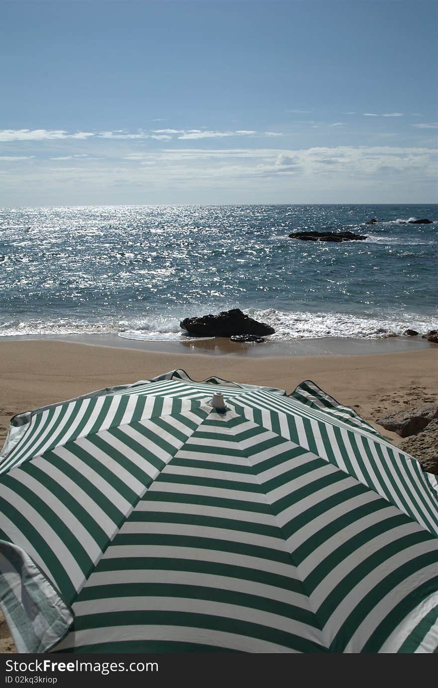 Green and white stripes umbrella at the beach