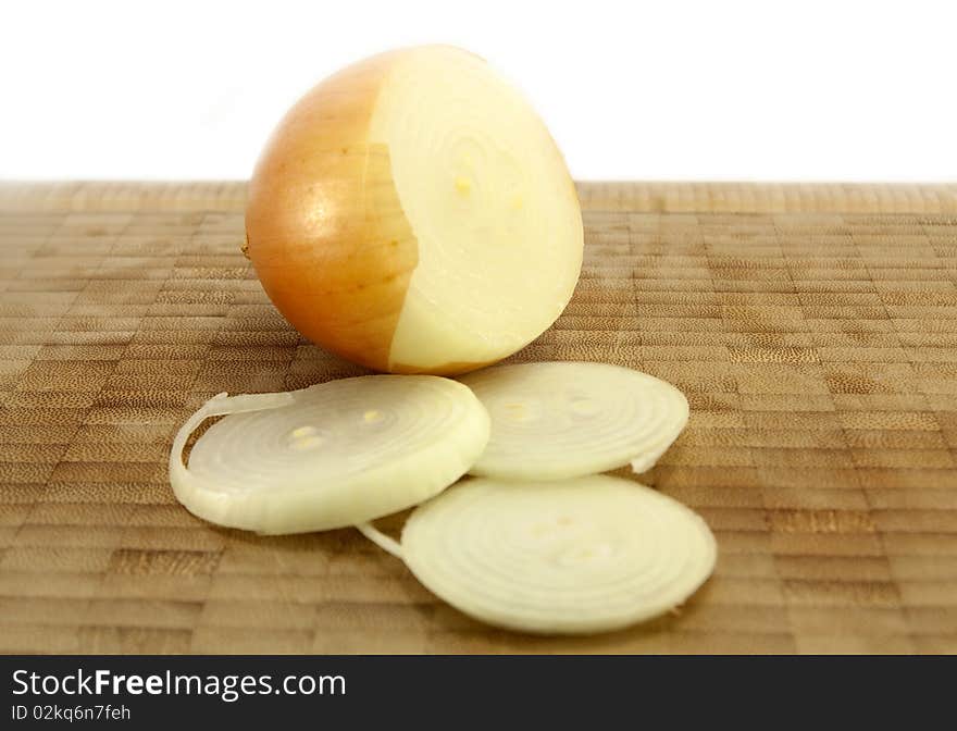 Sliced Organic Brown Onion on a wooden chopping board isolated on a white background. Sliced Organic Brown Onion on a wooden chopping board isolated on a white background