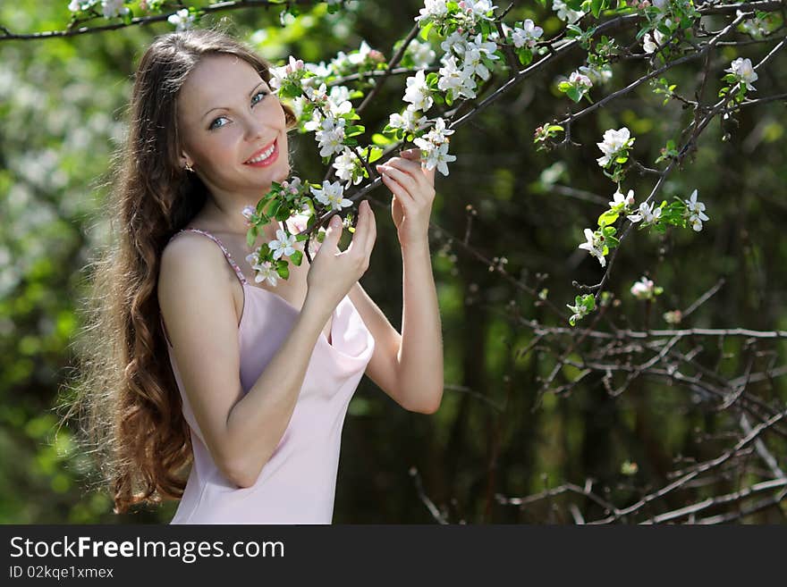 Pretty and beautiful smiling girl relaxing outdoor in flowering spring or summer apple garden. Pretty and beautiful smiling girl relaxing outdoor in flowering spring or summer apple garden