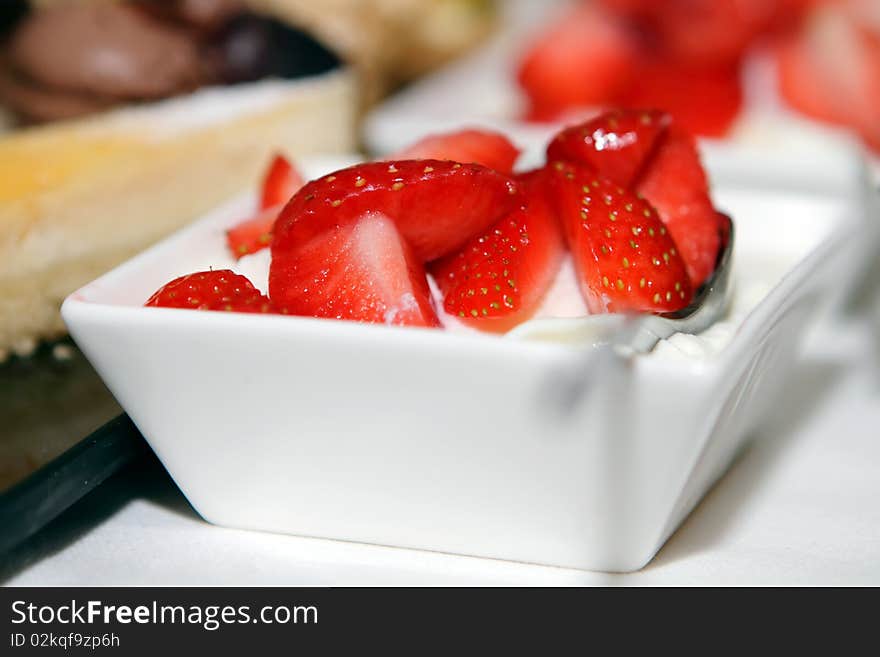 Fresh strawberries with whipped cream in dishes on the table