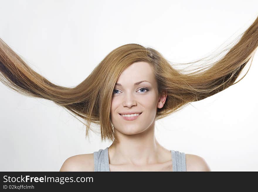 Young woman with hair flying over white. Young woman with hair flying over white