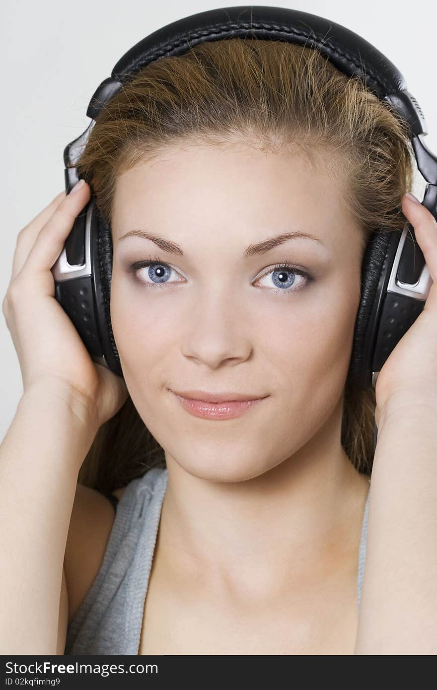 Beautiful young girl in headphones over white. Beautiful young girl in headphones over white