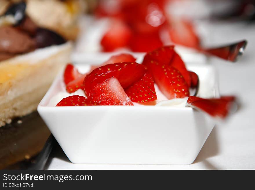 Fresh strawberries with whipped cream in dishes on the table