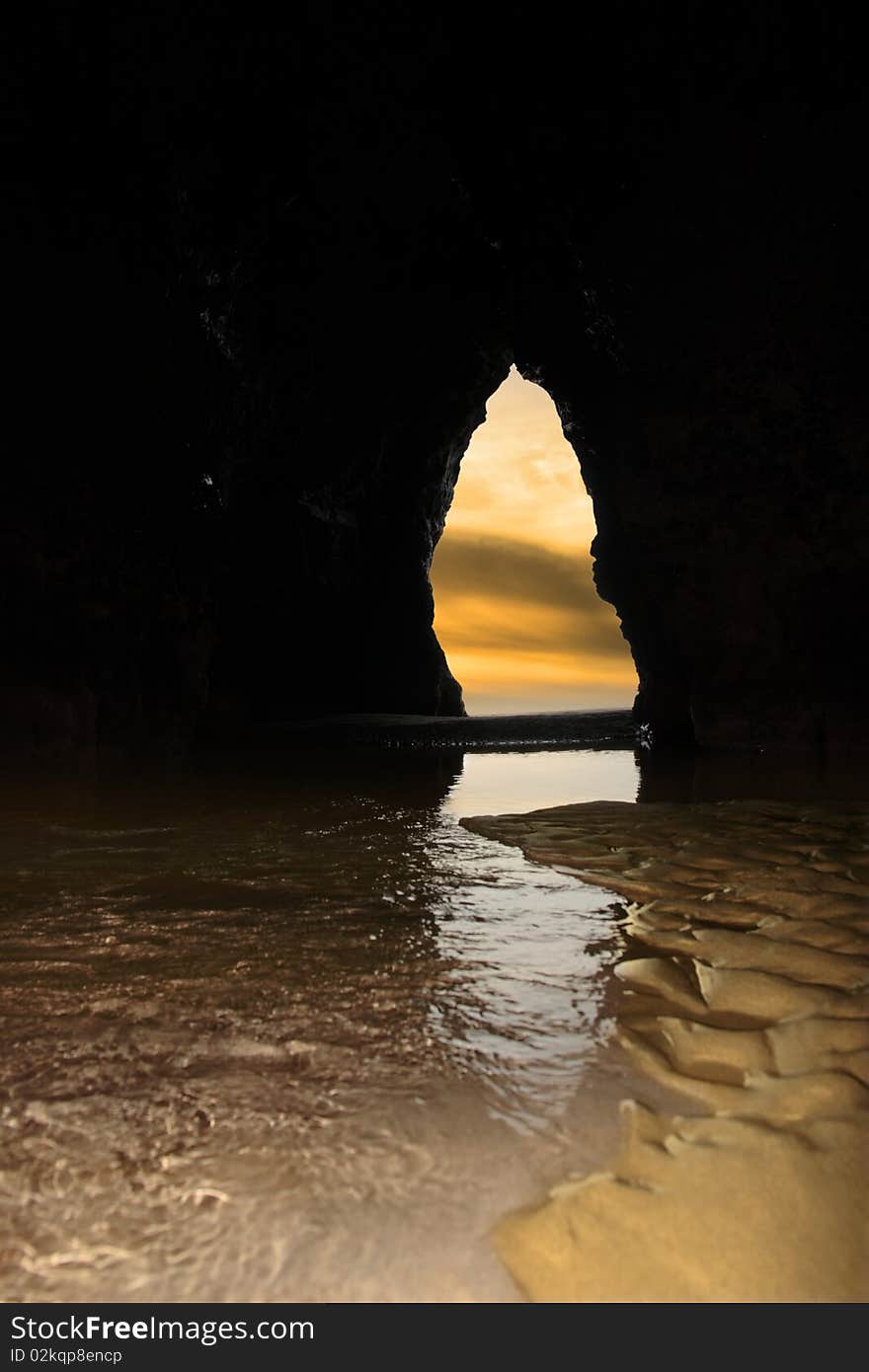 A view from the inside of a beach cave looking out at the sea. A view from the inside of a beach cave looking out at the sea