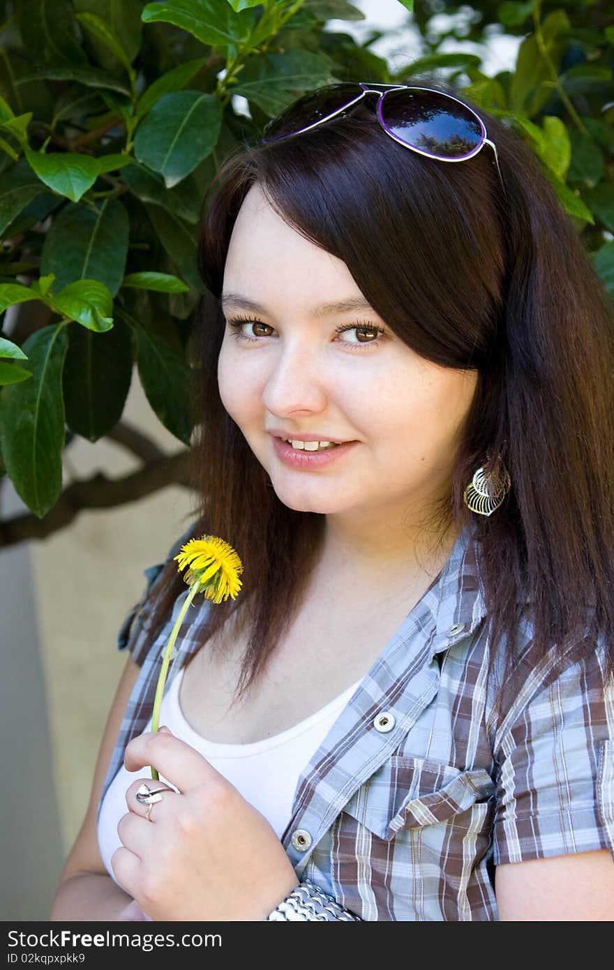 Portrait of a young girl with a dandelion