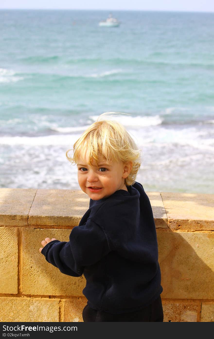 Happy little boy having fun on a coast structure. Happy little boy having fun on a coast structure.