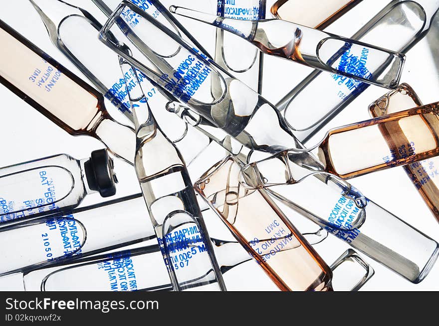 Heap of glass ampoules on a white background