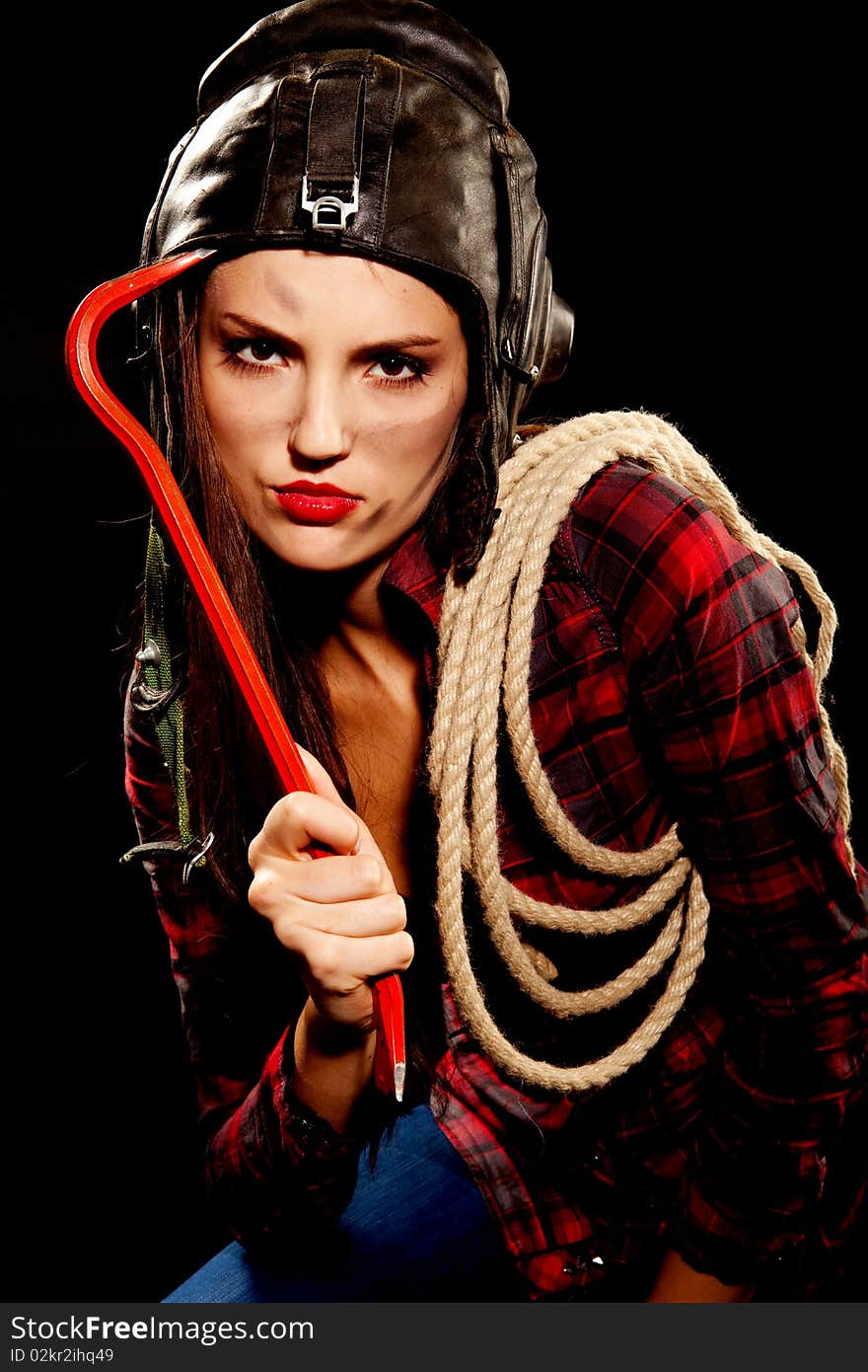 Young beautiful woman in cell shirt with red crowbar. Young beautiful woman in cell shirt with red crowbar