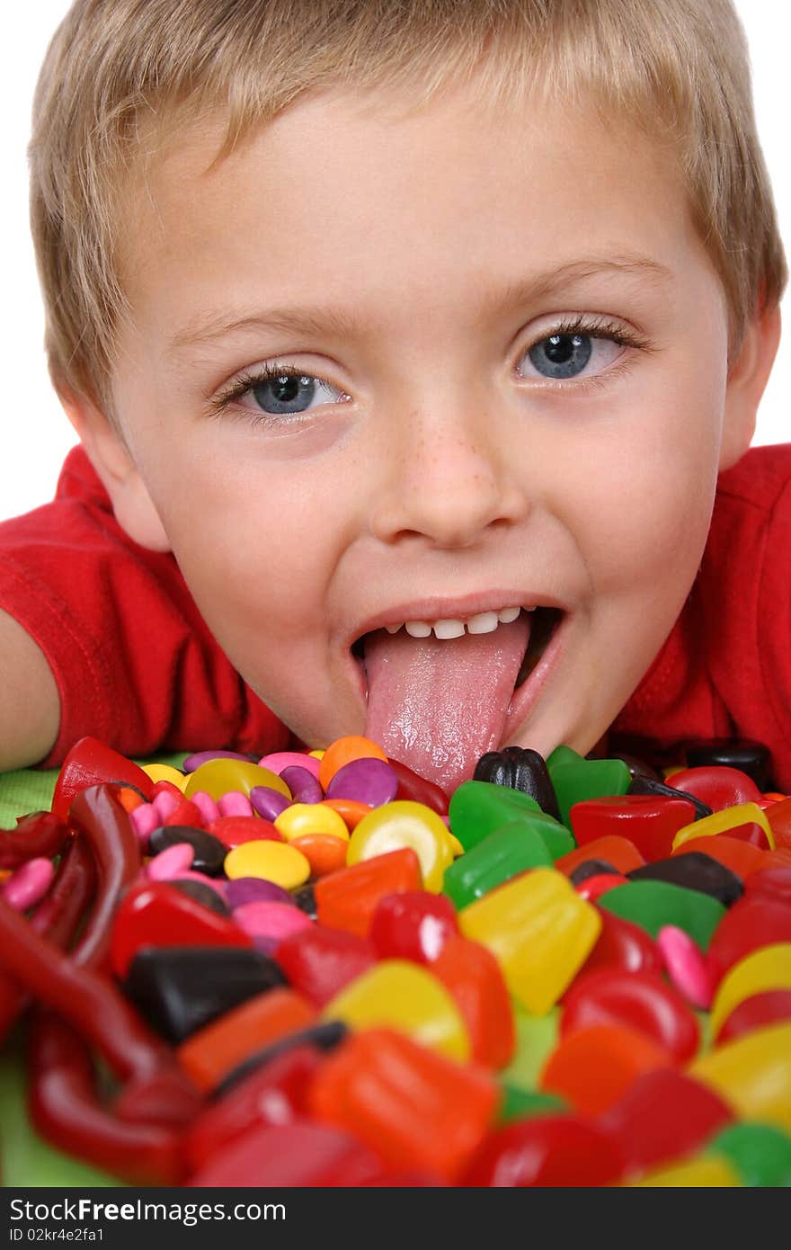 Young boy being with a table full of colorful sweets