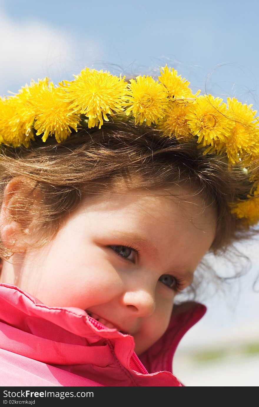 Girl and a wreath of dandelion against the sky. Girl and a wreath of dandelion against the sky