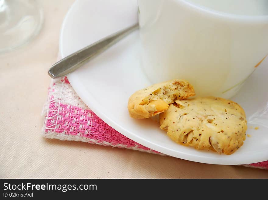 Healthy cookies half eaten with white cup and saucer. A healthy and nutritious afternoon snack. Concepts such as food and beverage, diet and nutrition, and healthy lifestyle. Healthy cookies half eaten with white cup and saucer. A healthy and nutritious afternoon snack. Concepts such as food and beverage, diet and nutrition, and healthy lifestyle.