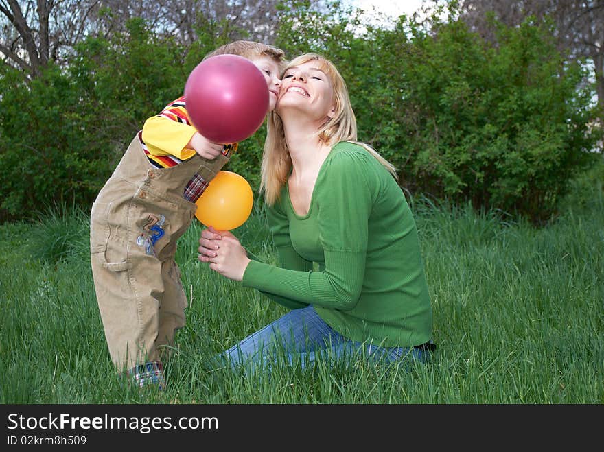 Mum with the son are played with balls in the spring on the nature. Mum with the son are played with balls in the spring on the nature