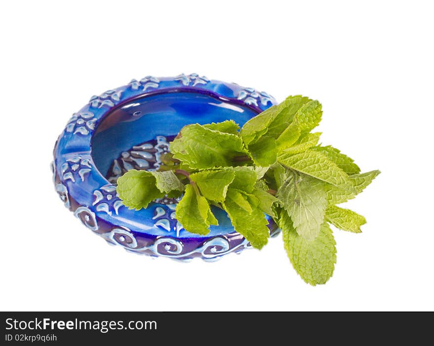 Ceramic ashtray with green mint isolated on a white background