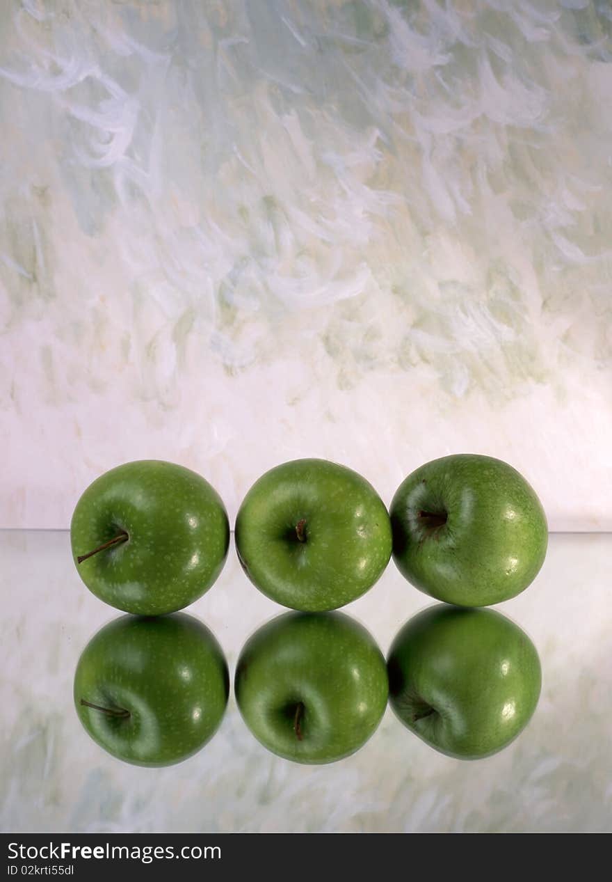 Three green apples isolated on mirror