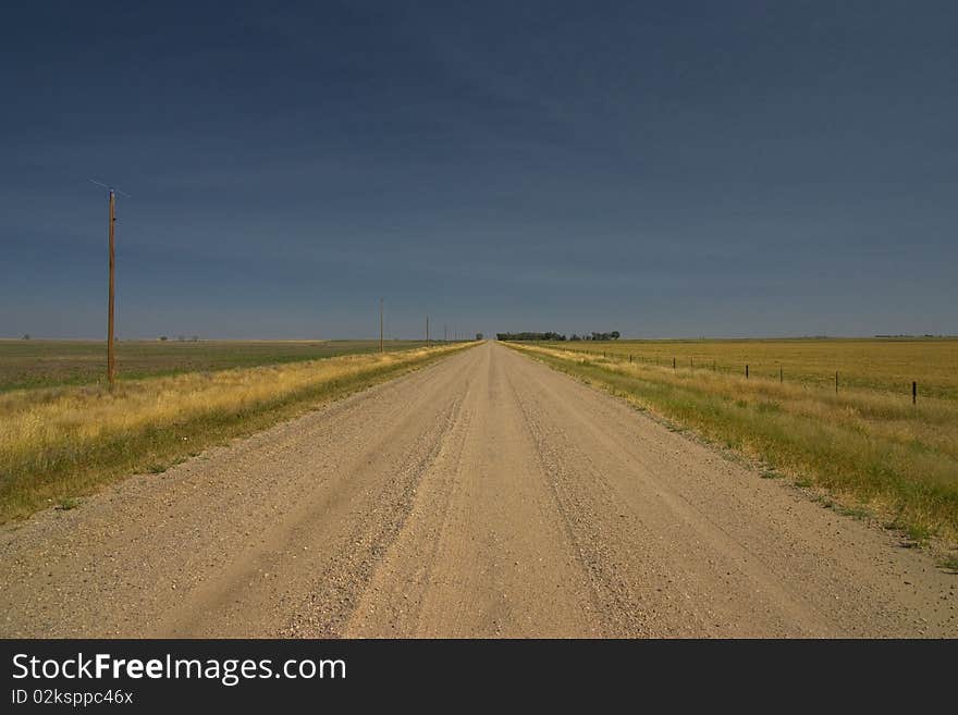 Straight dirt road crossing the plain in the state of Idaho