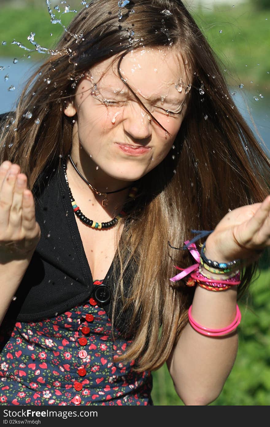 Beautiful teenage girl wash her face with pure water on nature background. Beautiful teenage girl wash her face with pure water on nature background