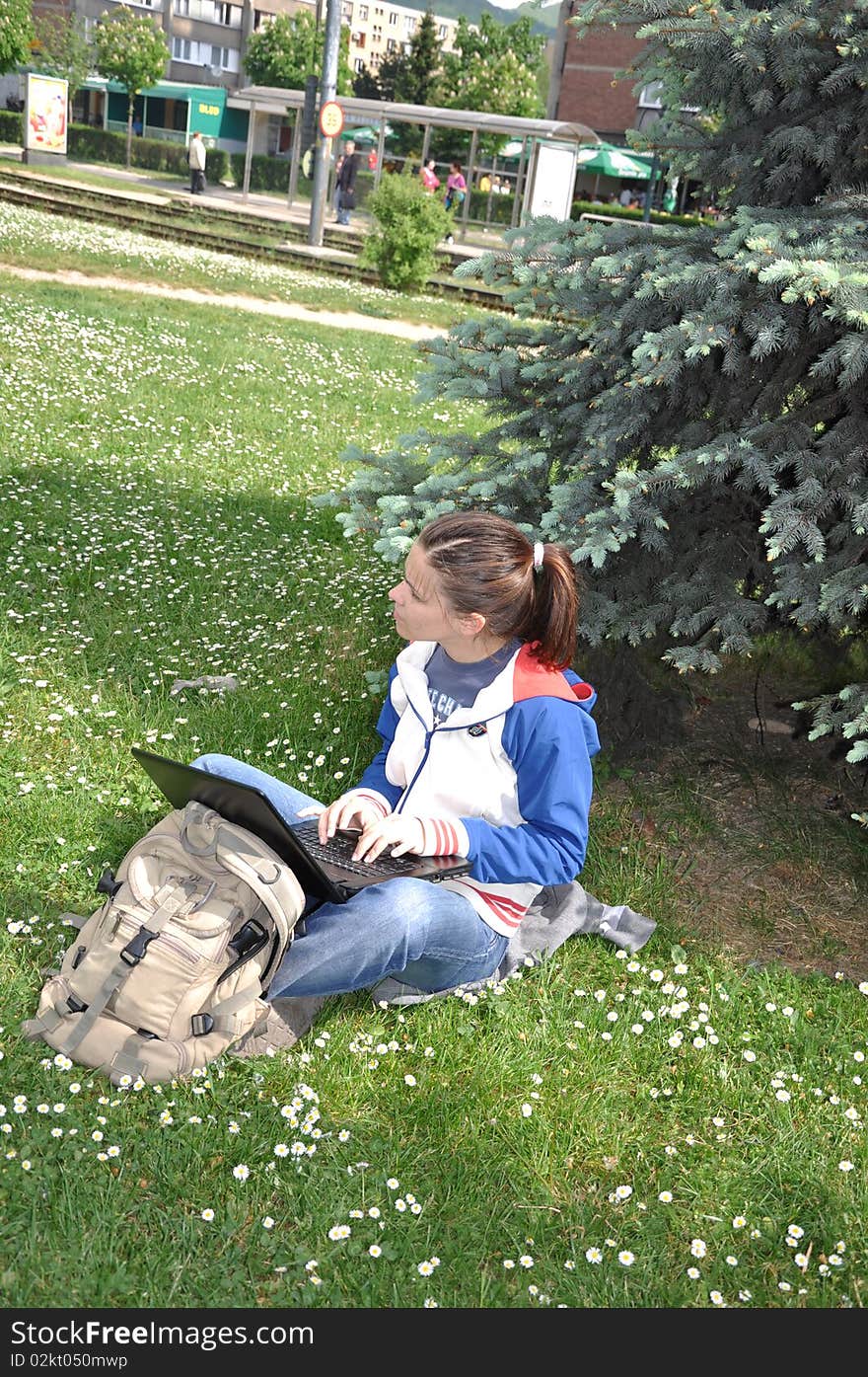 Young student learning outdoors with laptop