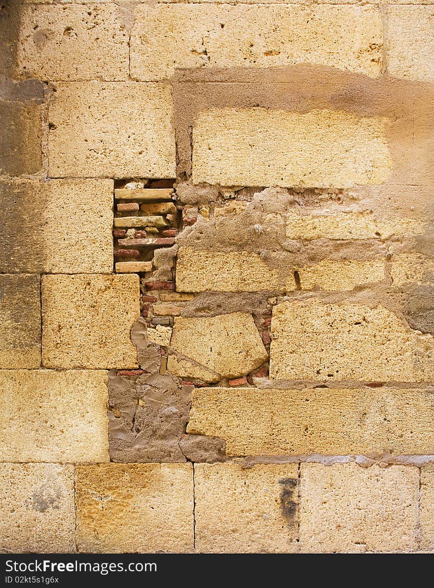 Closeup of stone wall. Yellow old wall from stones on the street. Closeup of stone wall. Yellow old wall from stones on the street