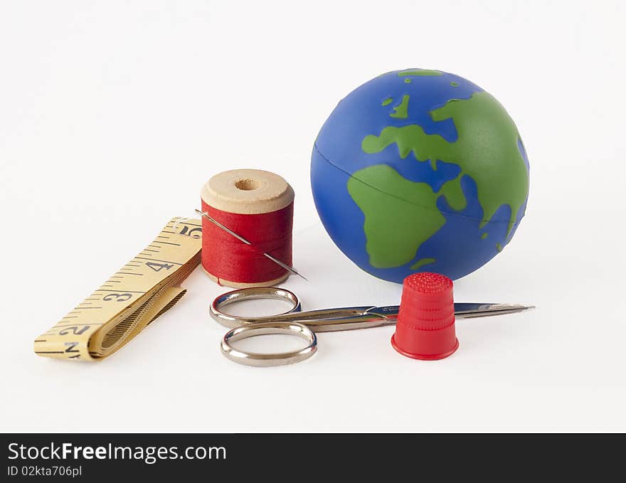 Sewing kit with a small globe representing the concept of mending the planet. Sewing kit with a small globe representing the concept of mending the planet