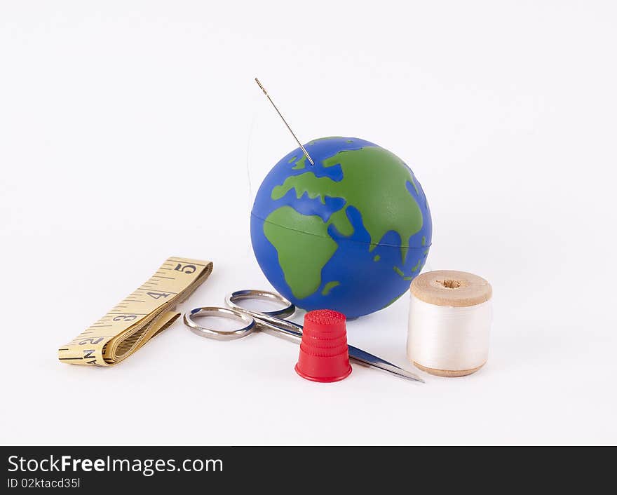 Sewing kit with a small globe representing the concept of mending the planet. Sewing kit with a small globe representing the concept of mending the planet