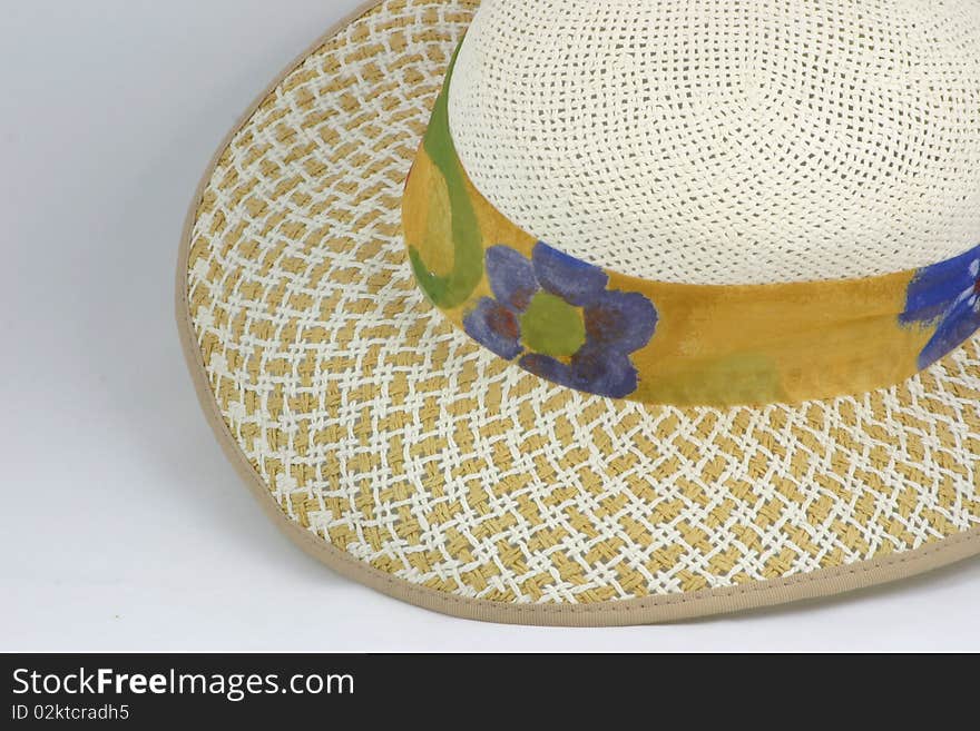 Straw hat with a ribbons of printed material around it. Straw hat with a ribbons of printed material around it