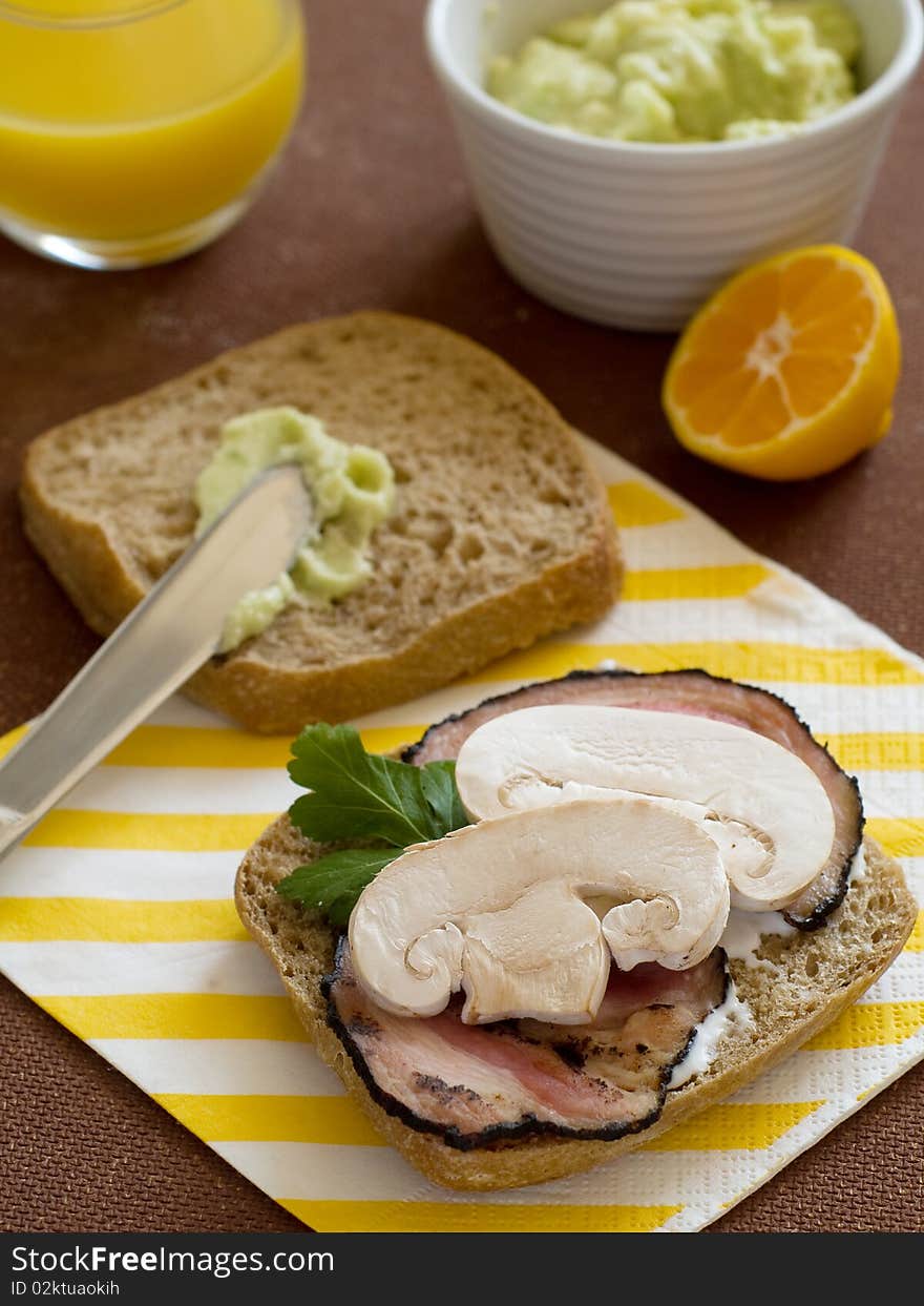 Toast with bacon, butter and mushrooms and orange juice for breaksfast. Toast with bacon, butter and mushrooms and orange juice for breaksfast