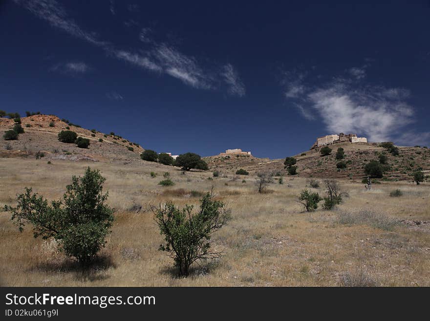 Old hystorical fort in mountain of Marocco with white clouds