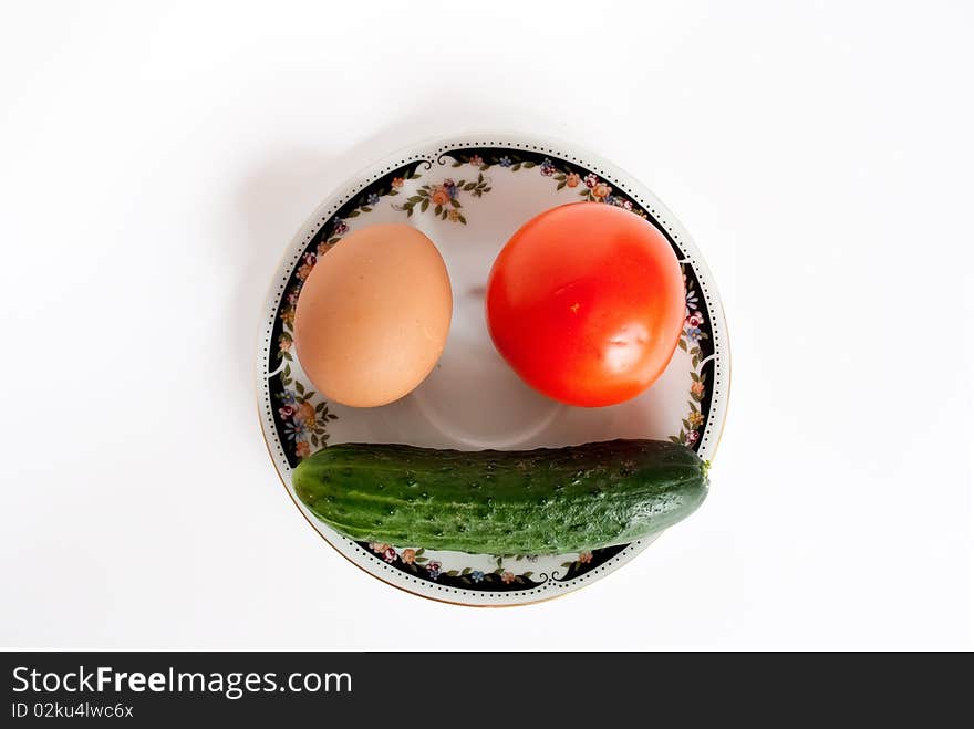 Egg, tomato and сucumber lie in the form of a smiling face. Egg, tomato and сucumber lie in the form of a smiling face