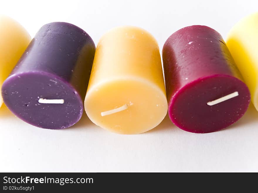 Colorful wax candle lying on white surface. Colorful wax candle lying on white surface