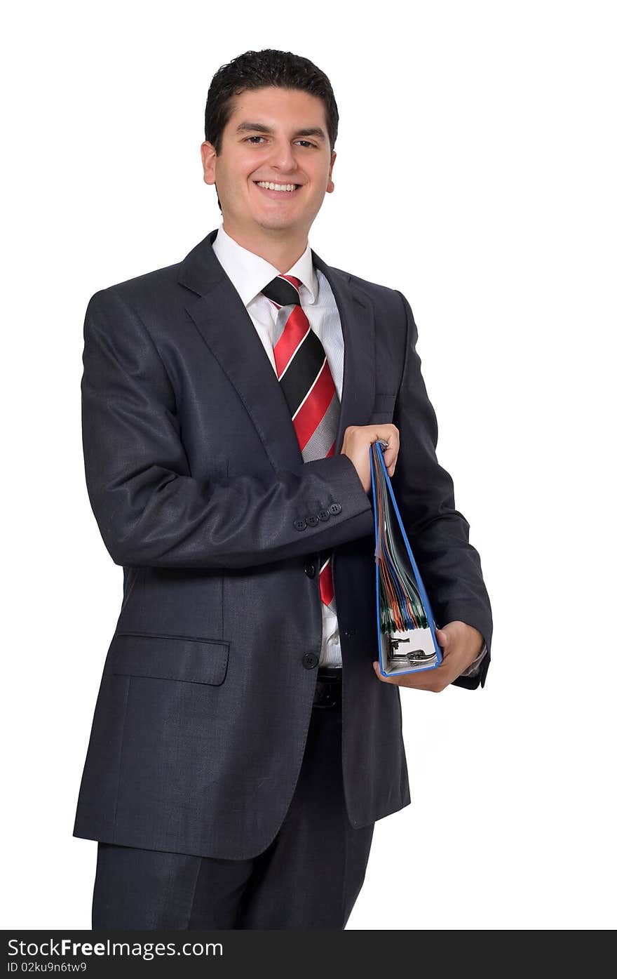 A young smiling businessman holding a binder full of files.