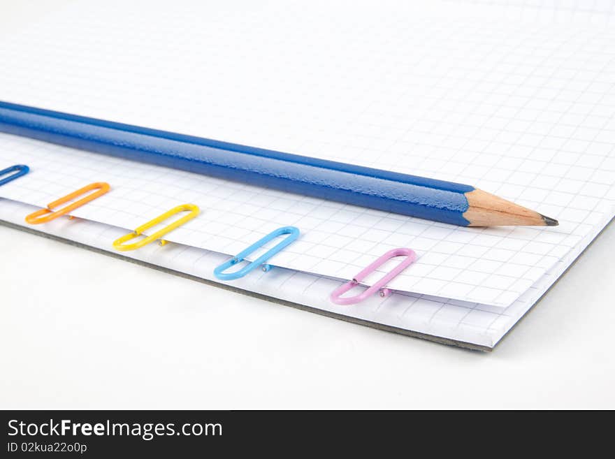 Paper clips and pencil on white background